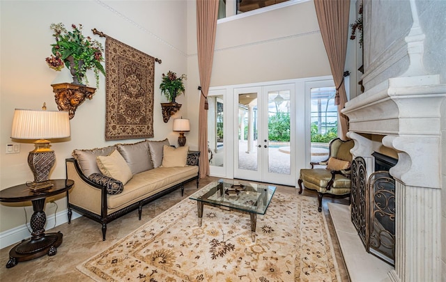 9943 Milano Dr, Trinity, FL 34655 - living area featuring baseboards, a fireplace, a towering ceiling, and french doors