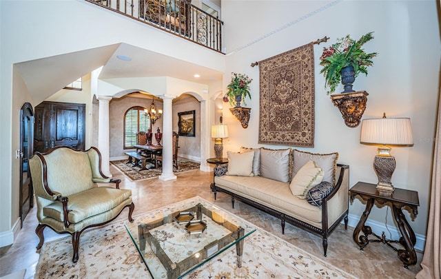 9943 Milano Dr, Trinity, FL 34655 - living area with baseboards, a high ceiling, arched walkways, and ornate columns