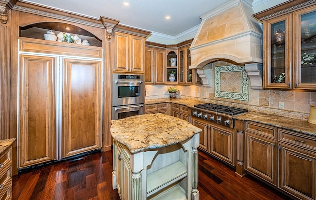 kitchen featuring a kitchen island, stainless steel appliances, light stone counters, and dark wood-type flooring