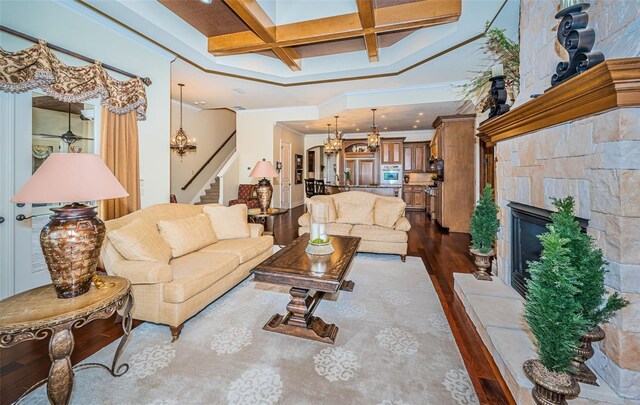 9943 Milano Dr, Trinity, FL 34655 - living area with coffered ceiling, stairway, a fireplace with raised hearth, beamed ceiling, and dark wood-type flooring