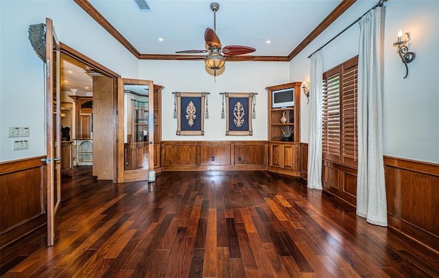 empty room with crown molding, wood walls, ceiling fan, and dark hardwood / wood-style floors