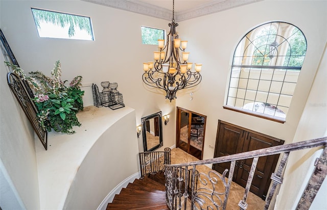 9943 Milano Dr, Trinity, FL 34655 - stairway with an inviting chandelier, ornamental molding, baseboards, a high ceiling, and wood finished floors