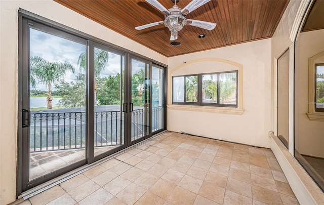 unfurnished sunroom featuring wood ceiling and ceiling fan