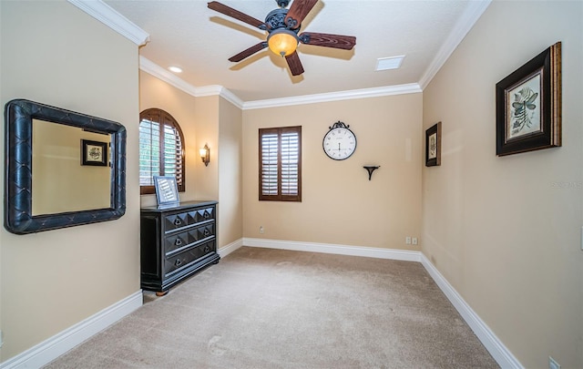 empty room with ornamental molding, ceiling fan, and carpet flooring