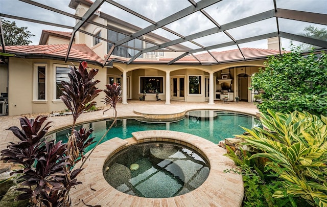 view of pool with a lanai, an in ground hot tub, and a patio