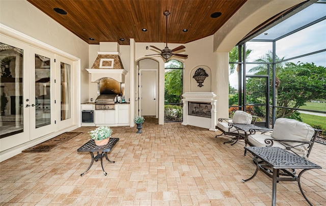 view of patio / terrace featuring glass enclosure, ceiling fan, grilling area, and french doors