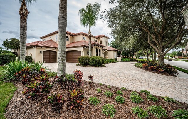 9943 Milano Dr, Trinity, FL 34655 - mediterranean / spanish home featuring stucco siding, a tile roof, and decorative driveway