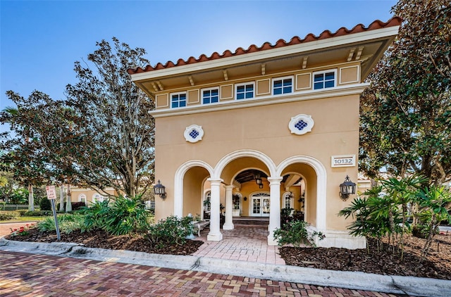 9943 Milano Dr, Trinity, FL 34655 - mediterranean / spanish home with stucco siding, a tile roof, and french doors
