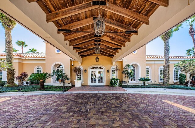9943 Milano Dr, Trinity, FL 34655 - property entrance featuring a tile roof, stucco siding, and french doors