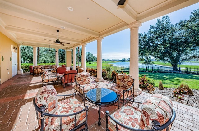 view of patio featuring a water view, outdoor lounge area, and ceiling fan