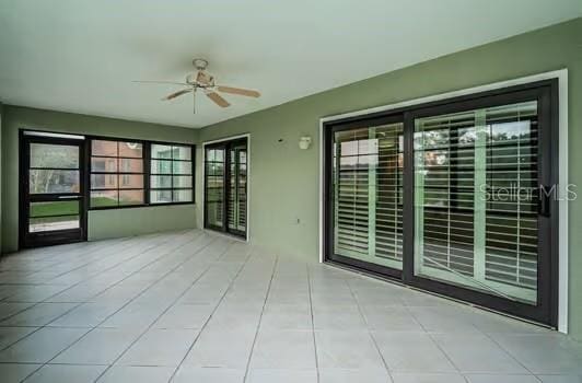 empty room with light tile patterned floors and ceiling fan