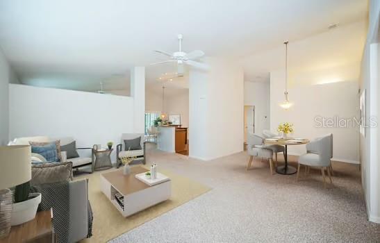 living room featuring ceiling fan, carpet, and a towering ceiling