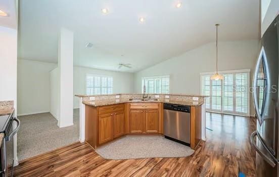 kitchen with lofted ceiling, sink, light hardwood / wood-style flooring, appliances with stainless steel finishes, and hanging light fixtures