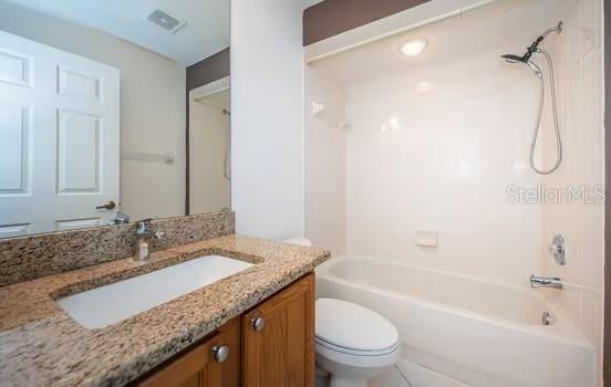 full bathroom featuring vanity, tub / shower combination, and toilet