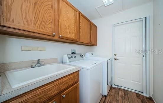 laundry room featuring cabinets, independent washer and dryer, dark wood-type flooring, and sink