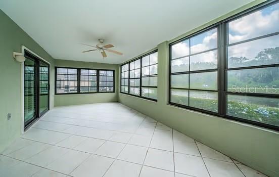 sunroom / solarium featuring ceiling fan