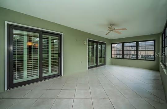 unfurnished sunroom with ceiling fan