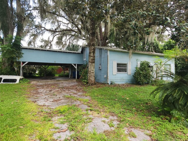 view of front facade with a carport and a front lawn