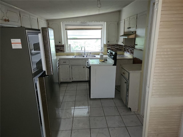 kitchen featuring lofted ceiling, stainless steel fridge, sink, white cabinetry, and washer / clothes dryer