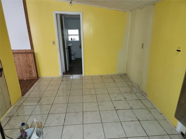 empty room featuring wood walls and light tile patterned floors