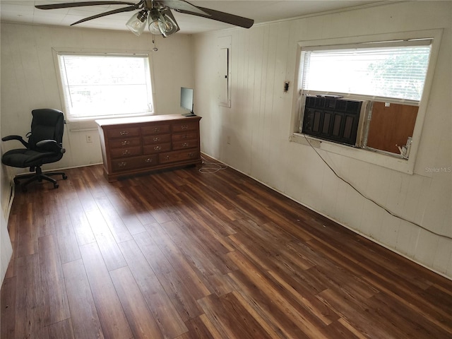 interior space with ceiling fan, dark hardwood / wood-style floors, and wood walls