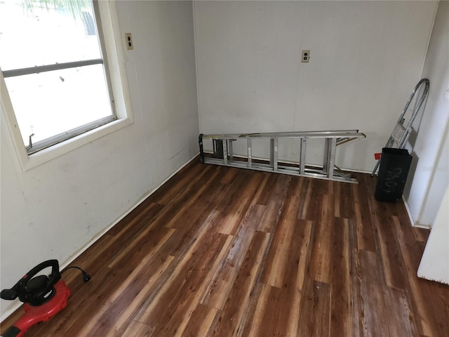 empty room featuring dark wood-type flooring and a wealth of natural light