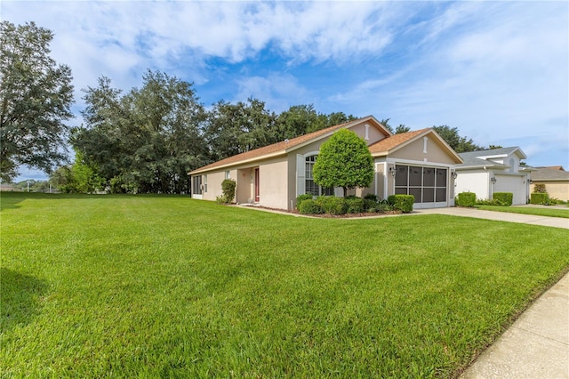 ranch-style home featuring a garage, a sunroom, and a front lawn