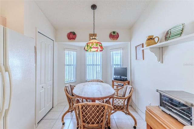 dining space featuring light tile patterned floors, a wealth of natural light, and a textured ceiling