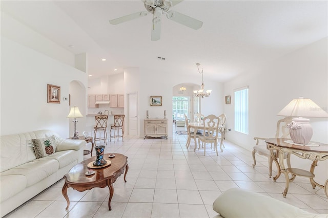 living room with light tile patterned floors and ceiling fan with notable chandelier