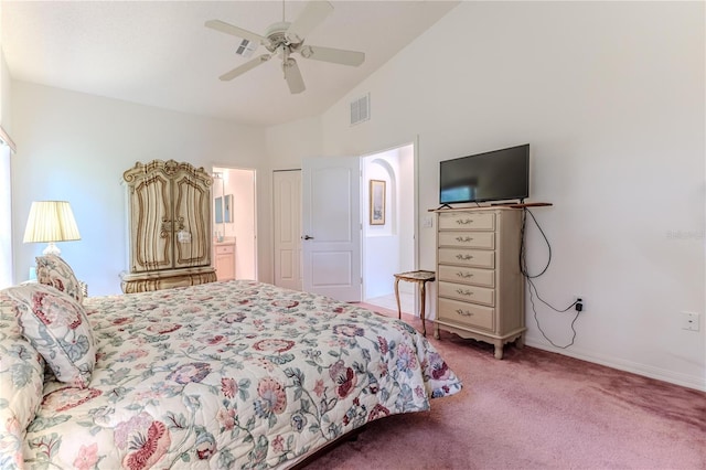 bedroom featuring ceiling fan, light carpet, ensuite bathroom, and vaulted ceiling