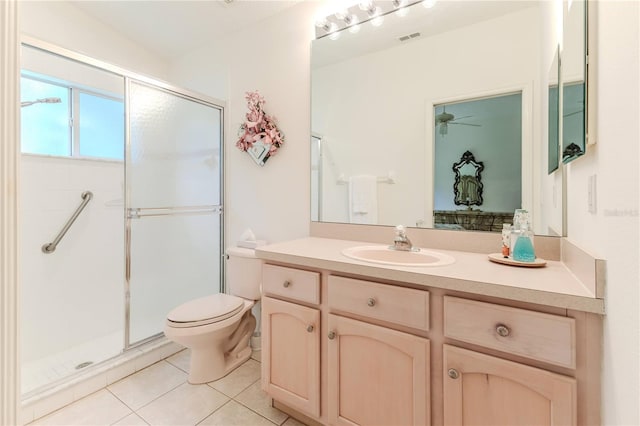 bathroom featuring a shower with door, vanity, toilet, and tile patterned floors