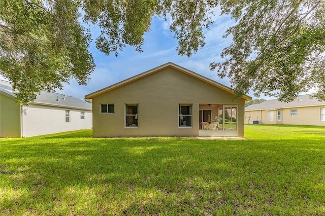 rear view of property featuring a sunroom and a yard