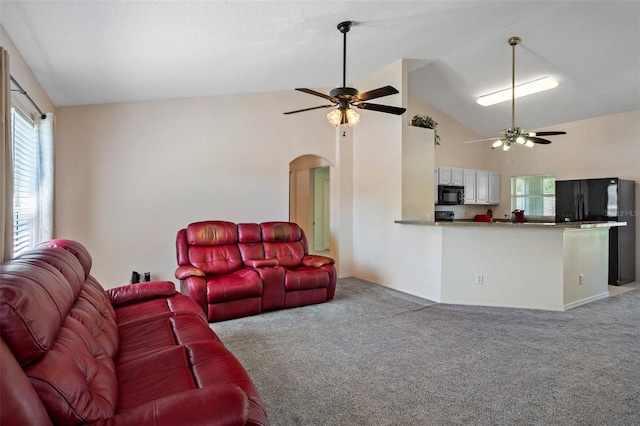 carpeted living room with high vaulted ceiling and ceiling fan