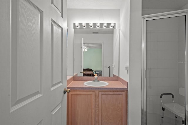 bathroom featuring walk in shower, vanity, toilet, and ceiling fan