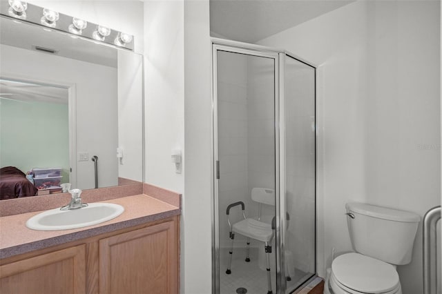 bathroom featuring vanity, toilet, and a shower with shower door