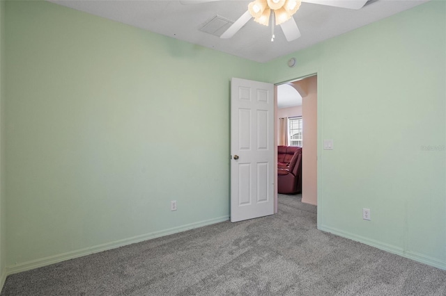 empty room featuring ceiling fan and light colored carpet