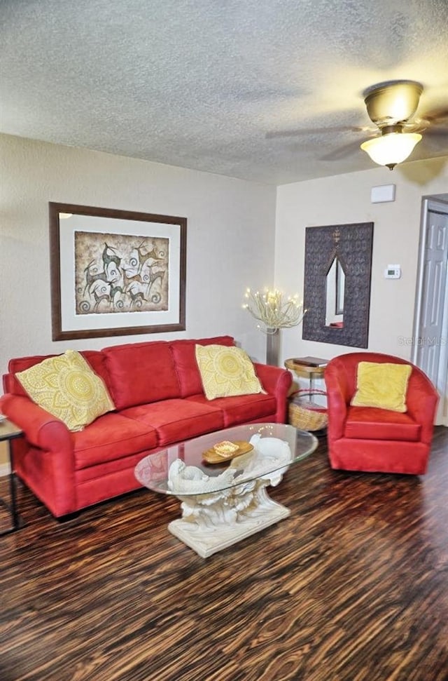 living room with a textured ceiling, wood finished floors, and baseboards