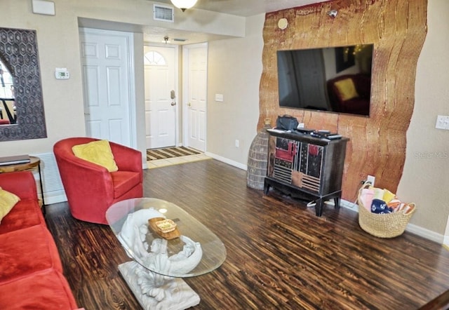 living area with visible vents, baseboards, and wood finished floors