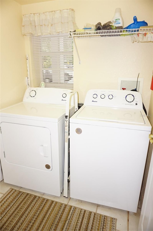 laundry room featuring light tile patterned floors and washing machine and dryer