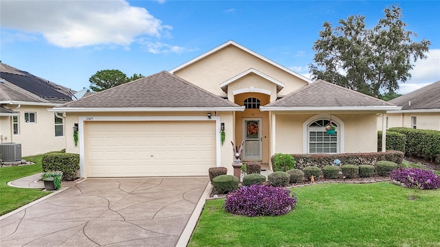 view of front of property with a garage, a front yard, and central air condition unit