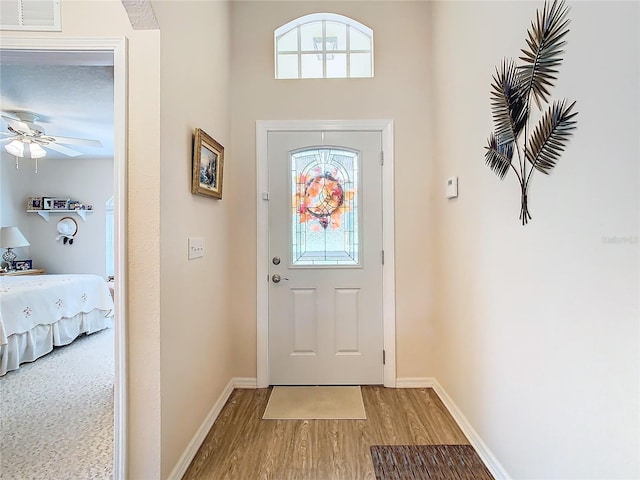 entryway with a healthy amount of sunlight, hardwood / wood-style floors, and ceiling fan