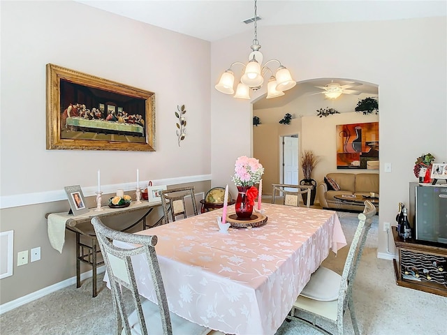 dining area with ceiling fan with notable chandelier and vaulted ceiling