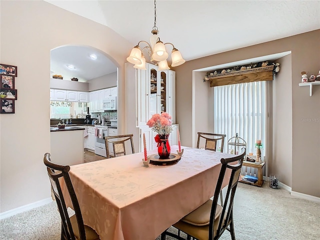 dining room featuring light colored carpet and a notable chandelier