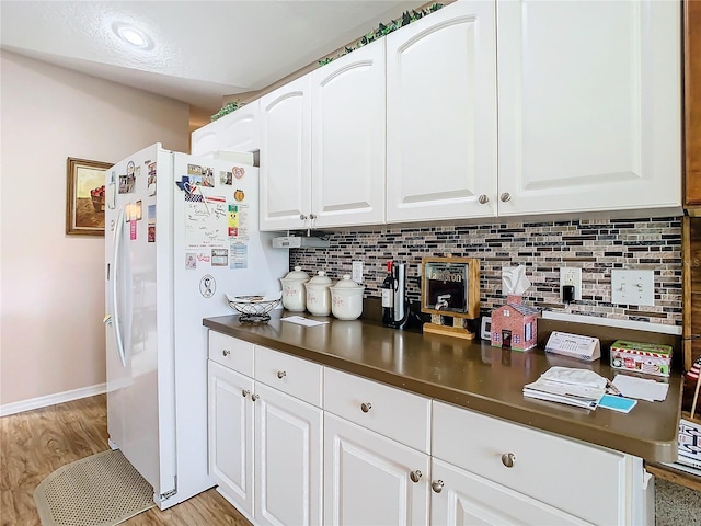 kitchen featuring white fridge with ice dispenser, light wood-type flooring, white cabinets, and tasteful backsplash