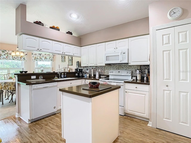 kitchen with light hardwood / wood-style flooring, a center island, white appliances, and white cabinetry