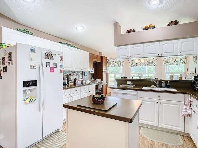 kitchen featuring light wood-type flooring, white appliances, white cabinetry, and sink