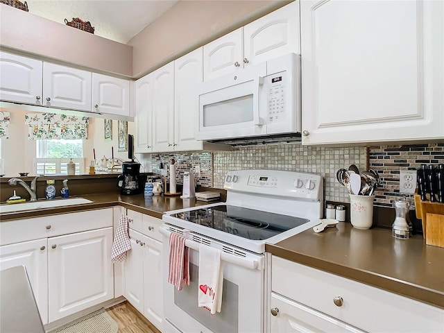 kitchen with white appliances, tasteful backsplash, sink, light wood-type flooring, and white cabinets