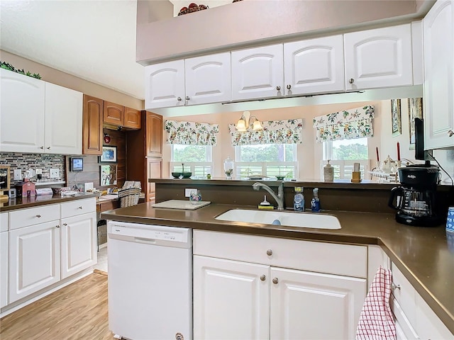 kitchen with white cabinetry, backsplash, dishwasher, sink, and light hardwood / wood-style floors