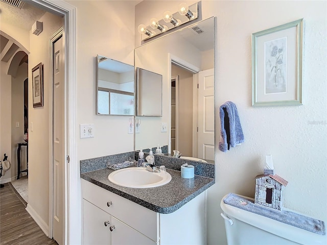 bathroom featuring vanity, toilet, and hardwood / wood-style floors