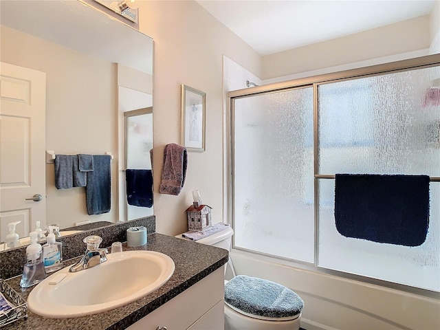 full bathroom with a healthy amount of sunlight, toilet, combined bath / shower with glass door, and vanity